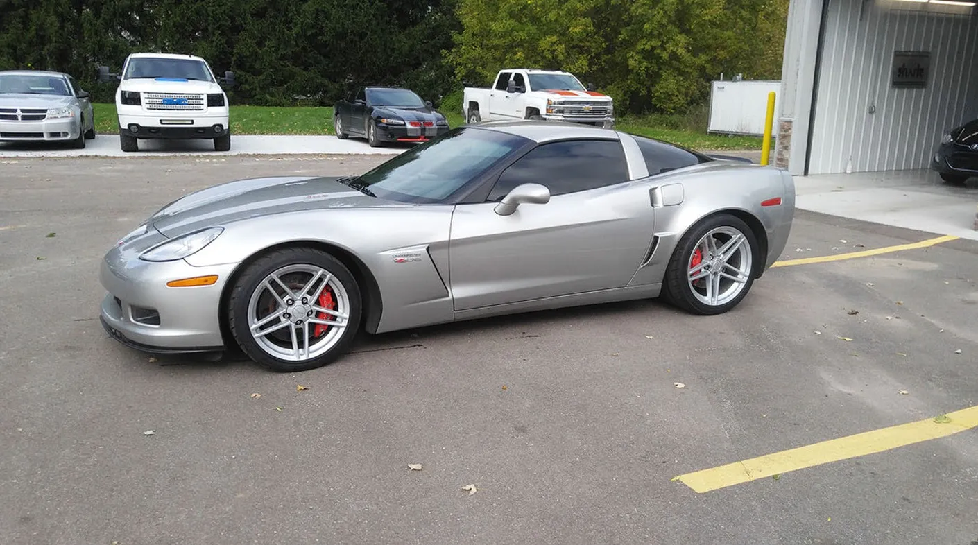 The same silver Corvette after front-end repair at Spanky's, back on its wheels in the lot
