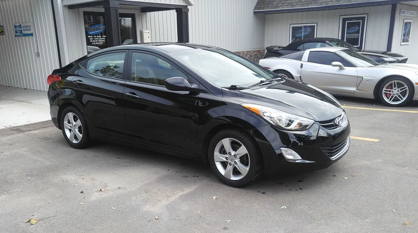 The same black Hyundai Elantra after repair at Spanky's, hood and bumper straight and refinished