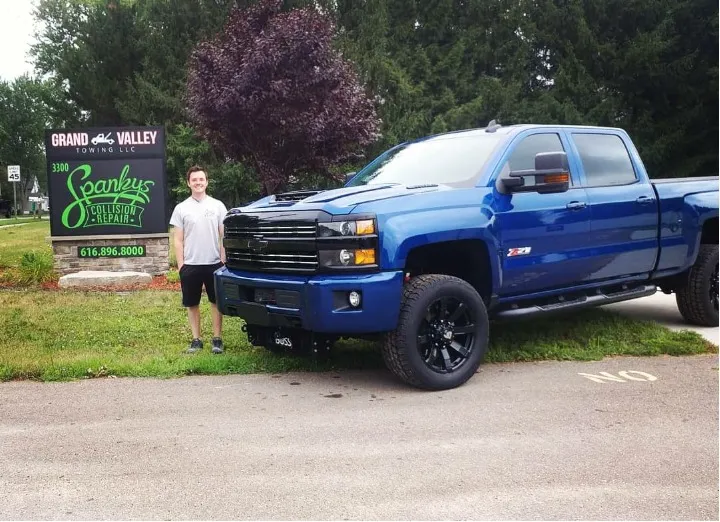 The Spanky's Collision Repair road sign at 3300 24th Ave in Hudsonville, MI, showing the shop name and phone number